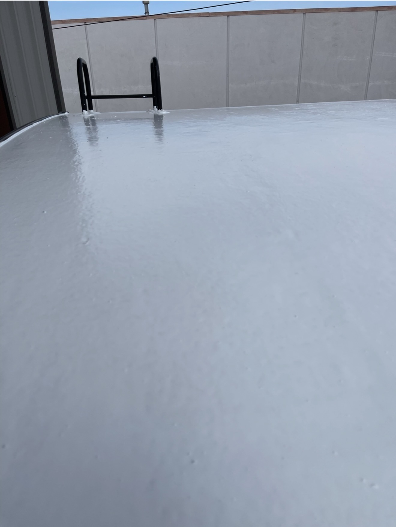 Worker applying 100% silicone roof coating to RV